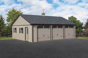 Triple wide garage with tan siding, black trim, a single entry door on the left side with window panels, 2 windows with black shutters, black roofing, a tan cupola, a brass weathervane, and 3 tan garage doors with window panels.