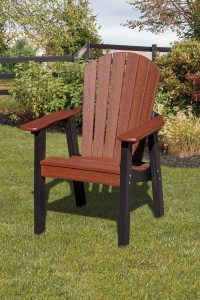 Black and brown poly furniture dining chair sitting in the grass outside.
