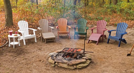 poly wood chairs around a backyard campfire