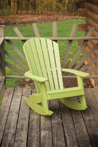 Lime green poly furniture rocking chair sitting on a wood deck.