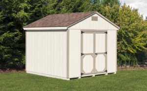 A frame small storage shed with white siding, tan trim, and tan roof