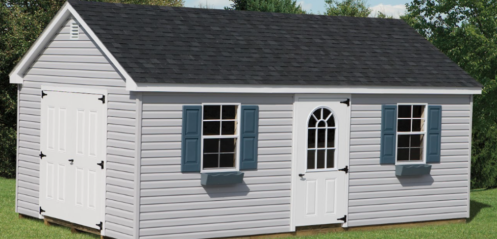 a-frame shed with two white doors, grey siding, and blue shutters on the windows