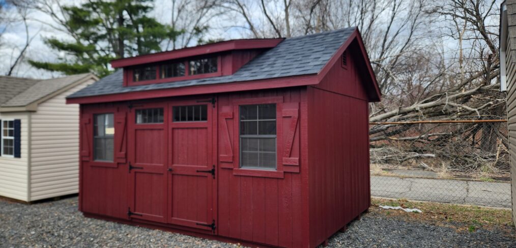transom dormer shed with red siding and black roof